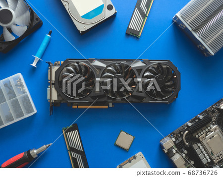 computer parts with harddisk, ram, CPU, graphics card, and motherboard on blue table background. 68736726