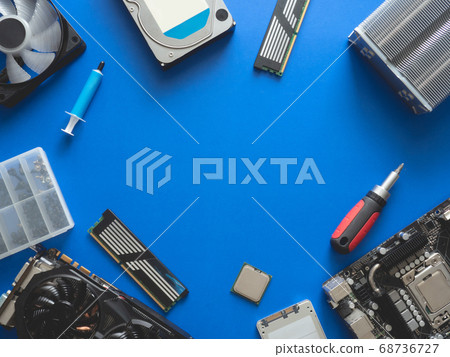 computer parts with harddisk, ram, CPU, graphics card, and motherboard on blue table background. 68736727