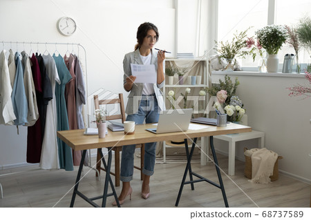 Concentrated young smart businesswoman recording audio message. 68737589