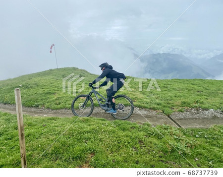 Unrecognicable biker on a mountainbike trail in Saalbach-Hinterglemm in the Austrian Alps in summer Unrecognicable biker on a mountainbike trail in Saalbach-Hinterglemm in the Austrian Alps in summer 68737739