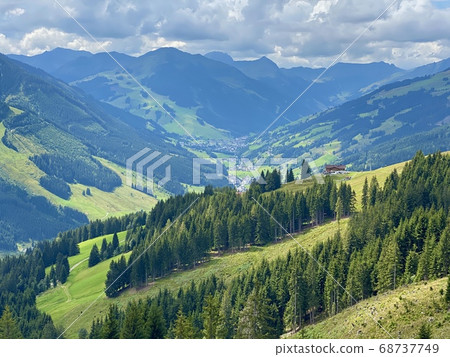 Aerial view on cozy hut with mountain panorama from Saalbach to Hinterglemm in the Alps in Austria on a sunny summer day 68737749
