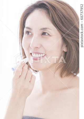 A woman applying lip balm A woman applying lip balm 68737952