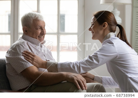 Smiling young kind female doctor supporting happy old 80s patient. 68738994