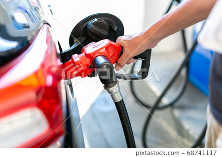 A man who refuels at a gas station 68741117