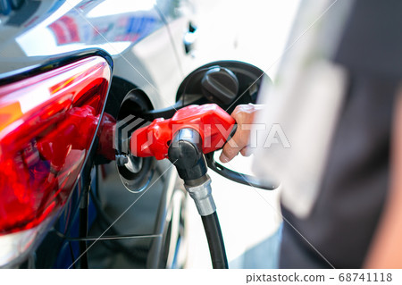 A man who refuels at a gas station 68741118