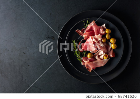 Prosciutto with rosemary and green olives on a 68741626