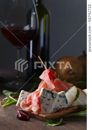 blue cheese with prosciutto , pear and red wine 68742728