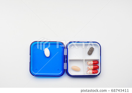 container with different capsules and tablets on a white background, concept image 68743411
