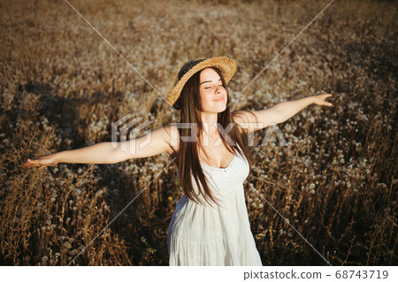 Beautiful woman walking alone in summer nature 68743719