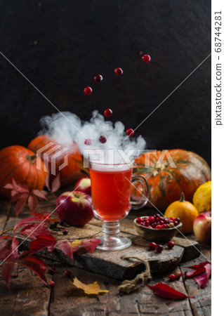 Autumn still life. Creative concept. Berries levitate over a cup of hot drink Autumn still life. Creative concept. Berries levitate over a cup of hot drink 68744281