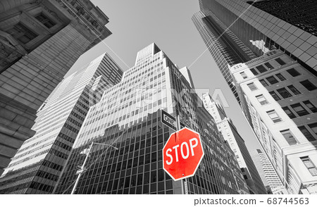 Red stop sign with black and white buildings, New York. 68744563