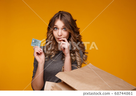 Young beautiful woman holding shopping bags and a credit card 68744861