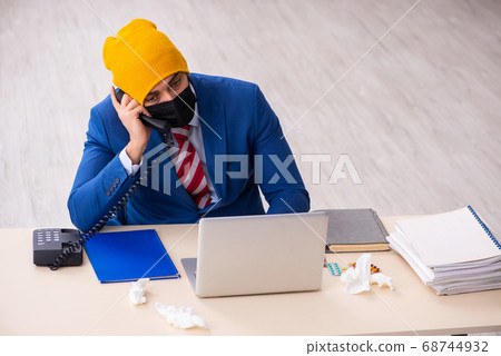 Sick male employee suffering at workplace from coronavirus 68744932