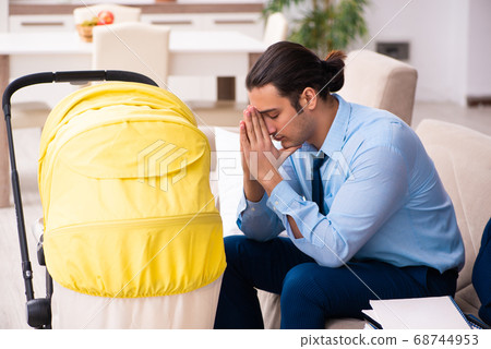 Young businessman looking after newborn at home 68744953