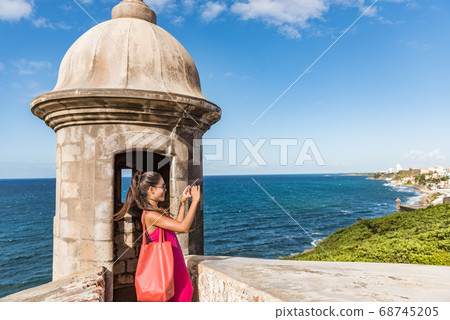 Puerto Rico San Juan woman taking phone pictures of Old San Juan Fort Castillo San Felipe Del Morro. Asian tourist people traveling in the USA visiting famous latin american landmark. Puerto Rico San Juan woman taking phone pictures of Old San Juan Fort Castillo San Felipe Del Morro. Asian tourist people traveling in the USA visiting famous latin american landmark. 68745205