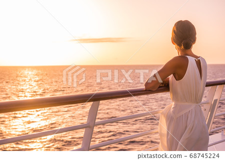 Cruise ship luxury travel holiday destination woman on Europe summer vacation. Elegant lady relaxing on outdoor deck looking at view of Mediterranean Sea. Cruise ship luxury travel holiday destination woman on Europe summer vacation. Elegant lady relaxing on outdoor deck looking at view of Mediterranean Sea. 68745224