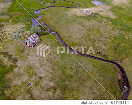 Aerial view of abandoned little wooden house barn next small river in the green valley, Aspen Spring Aerial view of abandoned little wooden house barn next small river in the green valley, Aspen Spring 68745314
