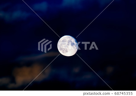 Full moon on cloudy vibrant blue lights night sky Full moon on cloudy vibrant blue lights night sky 68745355