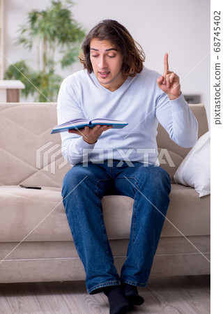 Young male student preparing for exams at home Young male student preparing for exams at home 68745402