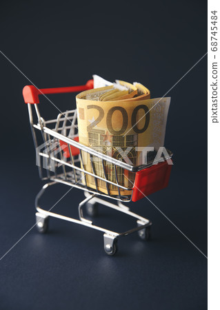 shopping cart filled with european currency notes, isolated on white shopping cart filled with european currency notes, isolated on white 68745484