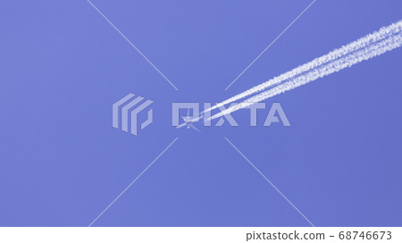 Airplane and white contrails in the blue sky Airplane and white contrails in the blue sky 68746673