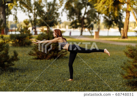 Young girl doing physical exercises in nature. 68748031