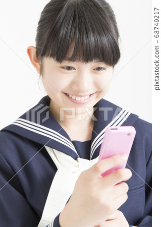 Junior high school girl looking at mobile mail Junior high school girl looking at mobile mail 68749217