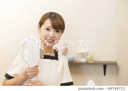 帶有商用脫毛機的美容師 帶有商用脫毛機的美容師 68749723