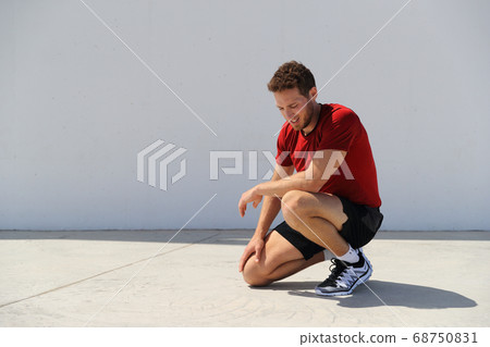 Tired sport fitness man exhausted breathing after difficult workout outdoors. Heat exhaustion athlete dehydrated or runner with knee injury pain resting in disappointment Tired sport fitness man exhausted breathing after difficult workout outdoors. Heat exhaustion athlete dehydrated or runner with knee injury pain resting in disappointment 68750831