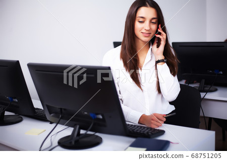 Woman sitting at desk, working on laptop in modern office Woman sitting at desk, working on laptop in modern office 68751205