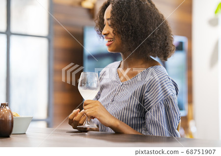 Young woman chatting with a wine glass in hand 68751907