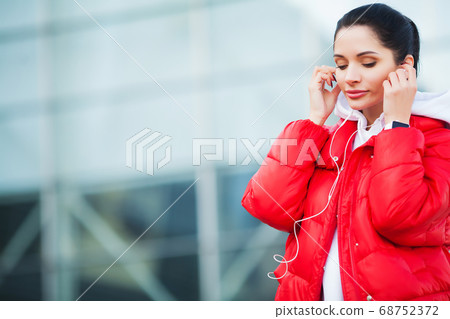 Fitness girl. Pretty sporty girl running and listening music outdoor. Healthy lifestyle in the big city Fitness girl. Pretty sporty girl running and listening music outdoor. Healthy lifestyle in the big city 68752372