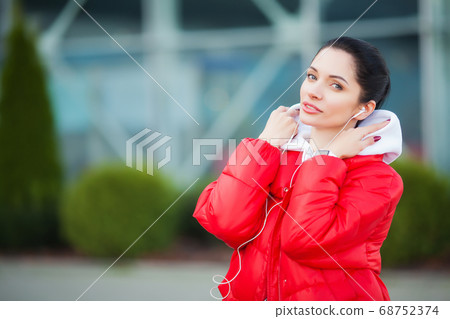 Fitness girl. Pretty sporty girl running and listening music outdoor. Healthy lifestyle in the big city 68752374