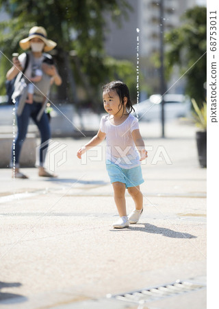 Children playing in the fountain in the square 68753011