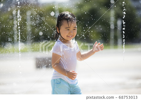 Children playing in the fountain in the square 68753013