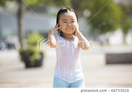 Children playing in the fountain in the square 68753028