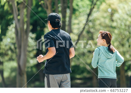 Men and women running/jogging/walking Men and women running/jogging/walking 68753227