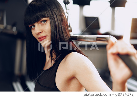 Close up photo of a young sporty woman working out in a gym Close up photo of a young sporty woman working out in a gym 68754172