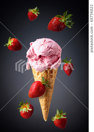 Strawberry ice cream in waffle cone. 68756822