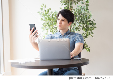 A man who sees a smartphone at work A man who sees a smartphone at work 68757502
