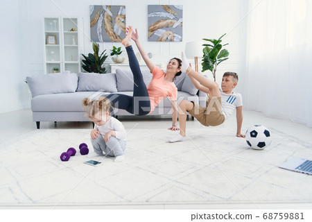 Young sporty mom with son doing morning warm-up exercises at home. Healthy family lifestyle concept 68759881
