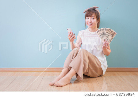 Asian woman with smartphone and money 68759954