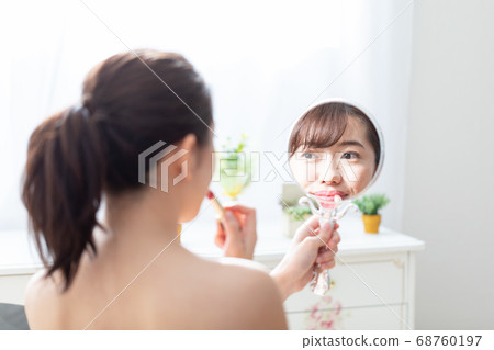 A woman applying a lip 68760197