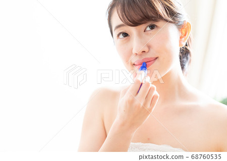 A woman applying a lip A woman applying a lip 68760535