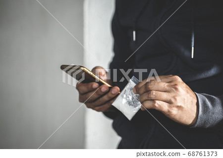 Junkie man holding drug syringe injection heroin 68761373