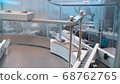 Glass bottles in production in the tray of an automatic liquid dispenser, a line for filling medicines against bacteria and viruses, antibiotics and vaccines 68762765