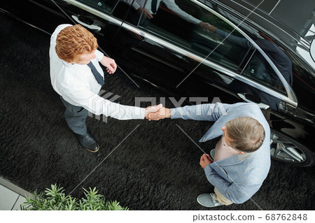 Top view of young sales manager in formalawear shaking hand of client Top view of young sales manager in formalawear shaking hand of client 68762848