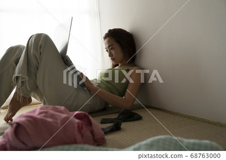 Woman relaxing and looking at computer 68763000