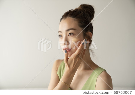 Woman doing make-up Woman doing make-up 68763007