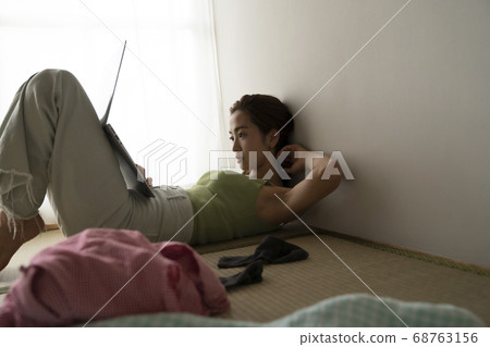 Woman relaxing and looking at computer Woman relaxing and looking at computer 68763156